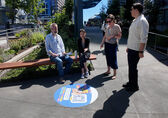 Four people look at a sidewalk decal in downtown Bellevue.