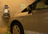 An electric vehicle is plugged into a parking garage charging station.