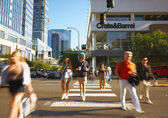 Shoppers walk across Northeast Eighth Street downtown.