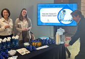 Utilities staff stand behind the Water-Smart Table in 2025.