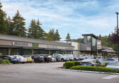 A row of restaurants and shops and the parking lot in front of them