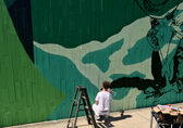 A man paints a mural.