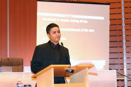 Speaker on a podium with CART backdrop behind on the wall