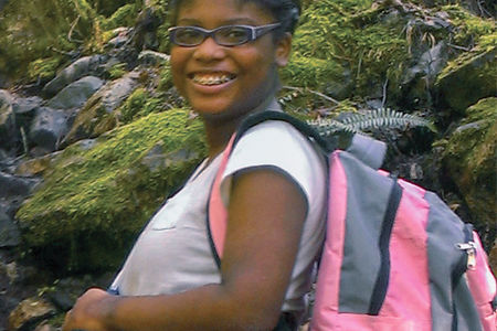 A smiling black girl with a backpack