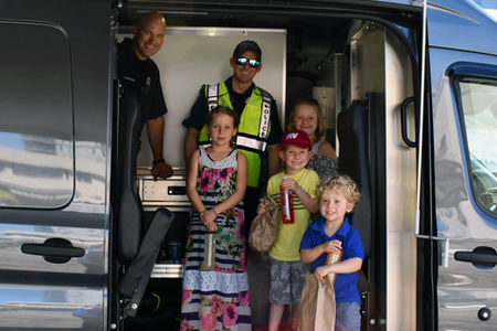 Four kids and two police in a van door