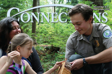 Cover of the November & December issue of Connections, featuring a park ranger showing a tree ring exhibit to a young participant and an adult.