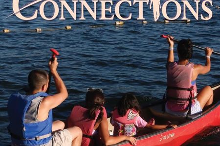 Cover of May-June 2022 Connections showing two adults and two children in a red canoe at Enatai Beach Park.