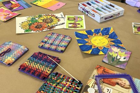 image of various fiber arts projects and paintings on a table