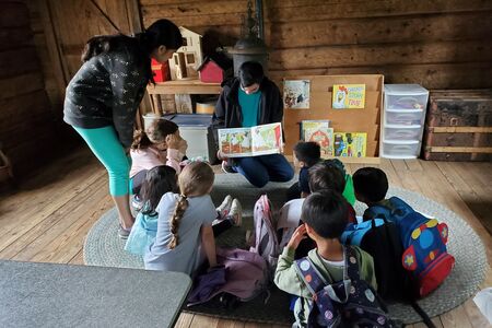 Counselors in training reading a book to a group of children
