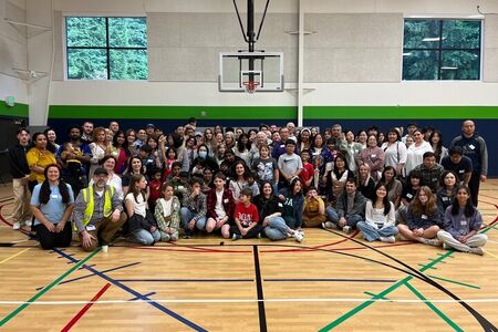 Group of children and adults in school gym.