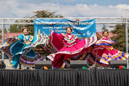 Baile folkorico dancers perform on stage in front of banner that says Bellevue International Festival.