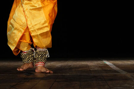   Closeup of Indian Kathak style male dancer with costume and bells tied to the legs.
