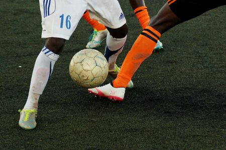 Soccer players kicking a soccer ball