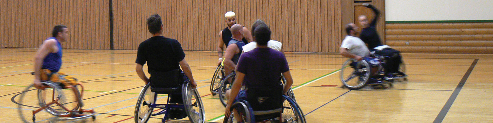 A group of man in wheelchairs playing basketball