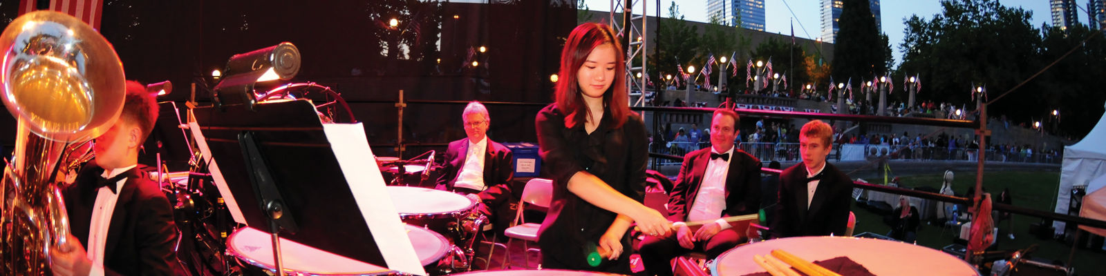 orchestra playing, a woman playing on drums