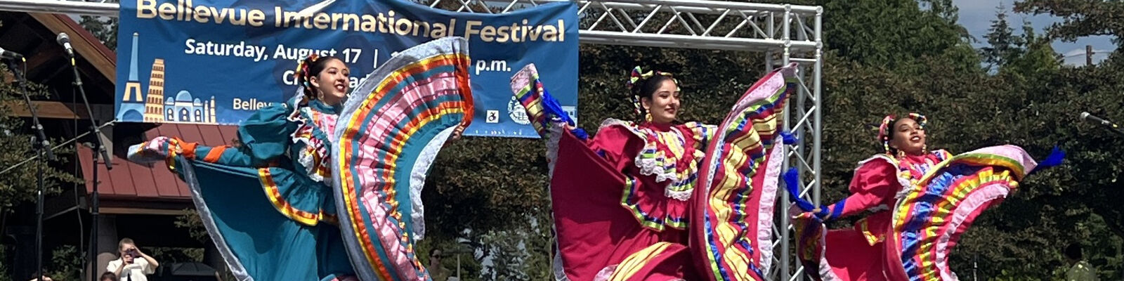 Women in colorful dresses dance on a stage..