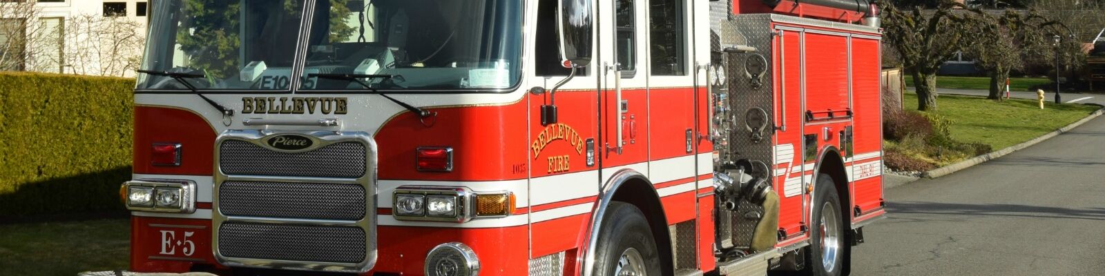 Bellevue Fire Engine 5 parked in a neighborhood with cityscape in the background.