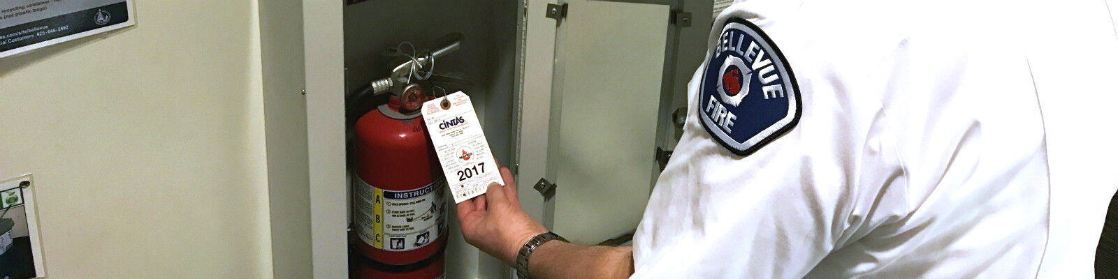 A Bellevue Fire Prevention Officer inspects a fire extinguisher. 
