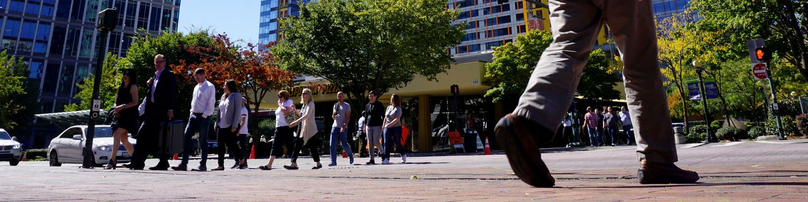 Image of pedestrians walking in a downtown crosswalk