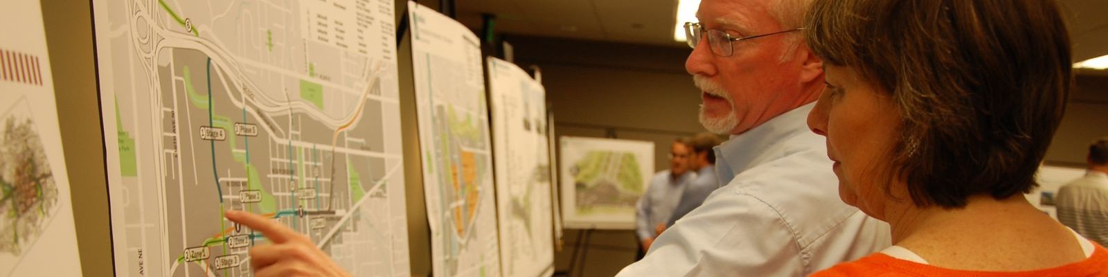 Image of person pointing at a map during an open house