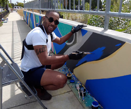 Artist Barry Johnson paints a mural in BelRed.