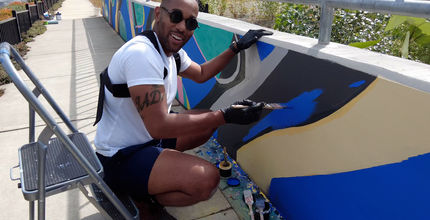 Artist Barry Johnson paints a mural in BelRed.