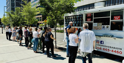 People line up for lunch at Momo's Kebabs food truck, which is parked at City Hall..