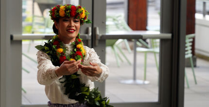 A woman with flowers in her hair dances at City Hall.