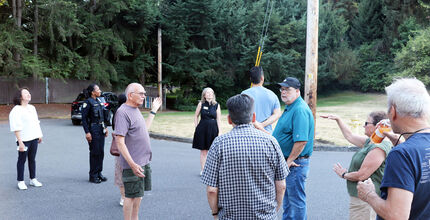People talk on a street in Surrey Downs for Neighborhood Walks.