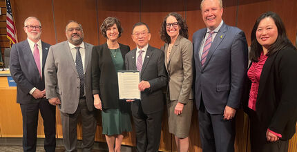 Councilmember Conrad Lee, center, accepts a commendation for his many years on the council.