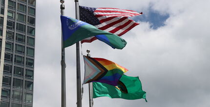 The pride flag flies alongside ones for the city, state and country.