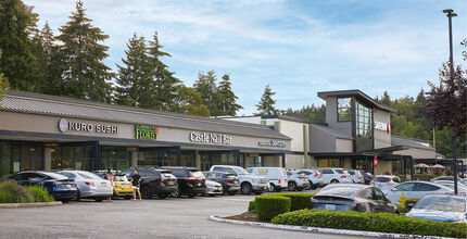 A row of restaurants and shops and the parking lot in front of them