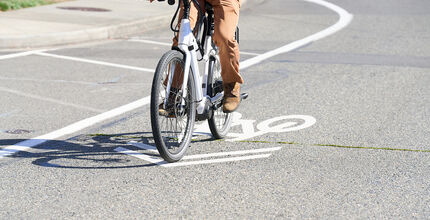 A person rides an e-bike on a Bellevue street.