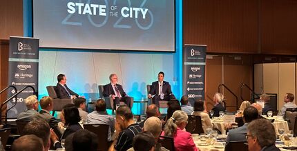 Mayor Mo Malakoutian (right) and Deputy Mayor Dave Hamilton (center) discuss Bellevue while seated on the stage at Meydenbauer Center.