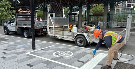 A contractor marks a large rectangle on a Bellevue sidewalk where Lime devices should be parked.