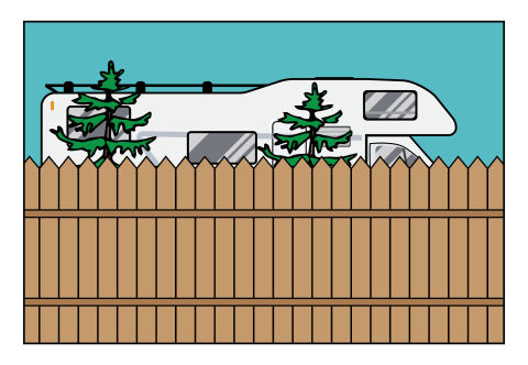 A brown fence partially screens a recreational vehicle. Trees are visible between the fence and the vehicle.