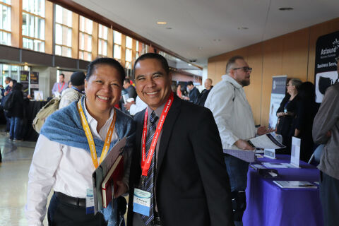 Two people smiling at the camera at the Innovation Exchange event.