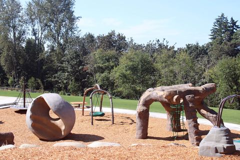 The playground at Newport Hills Woodlawn Park features play structures that look vaguely like animals.