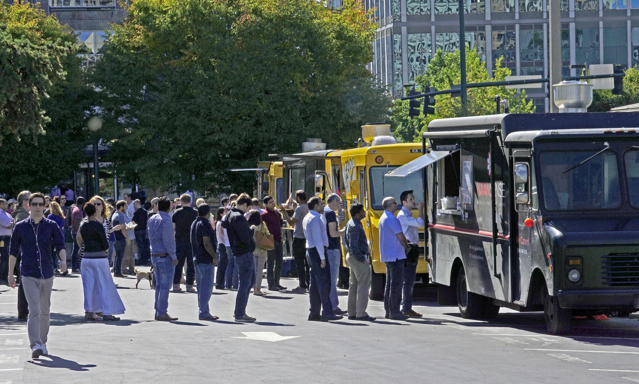 People line up for food trucks parked downtown.
