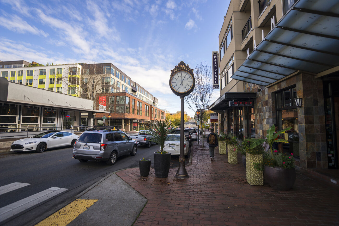 Photo of block on Old Main St. showing clock, businesses and cars on road in downtown Bellevue. 