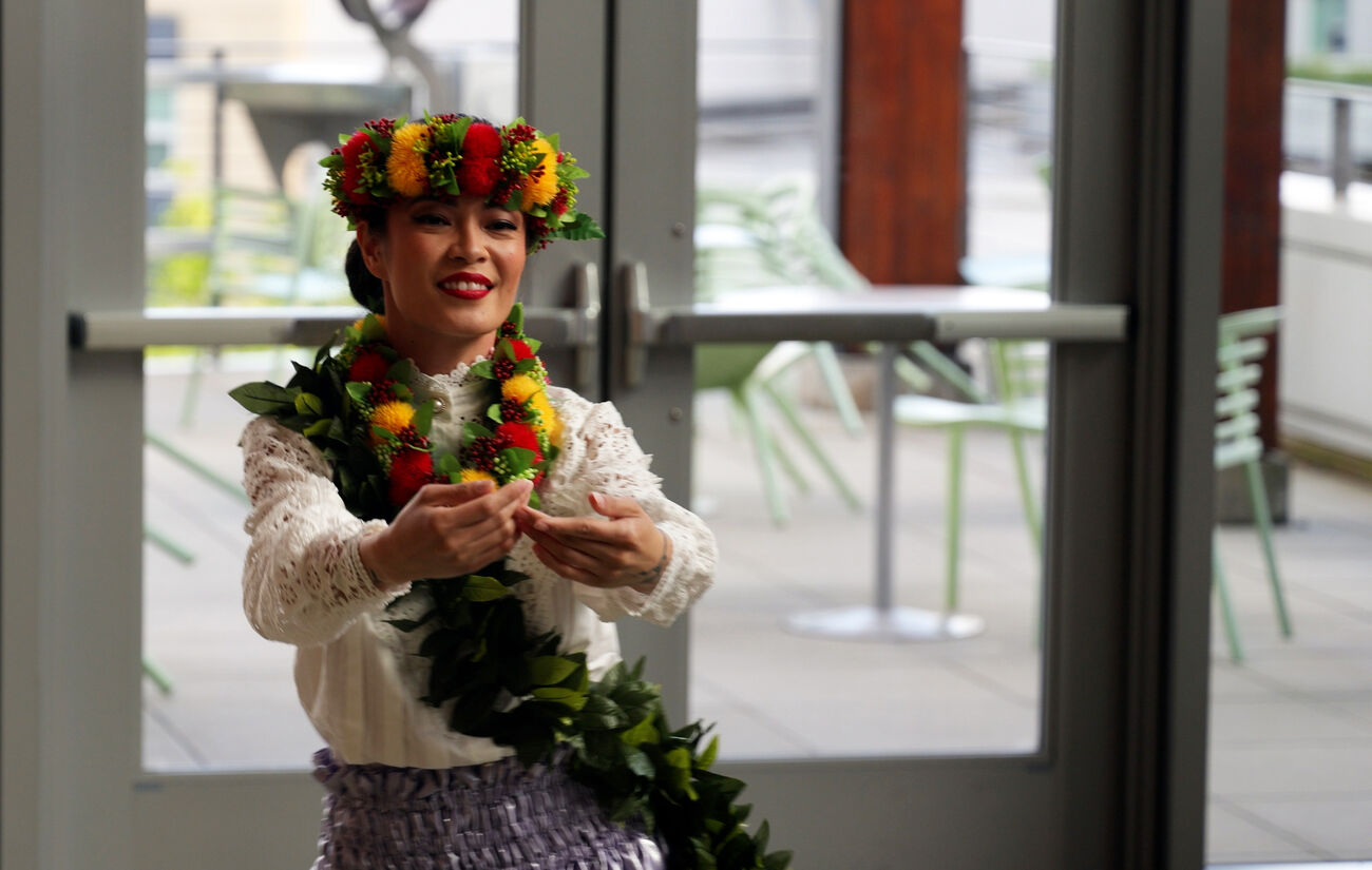 A woman with flowers in her hair dances at City Hall.