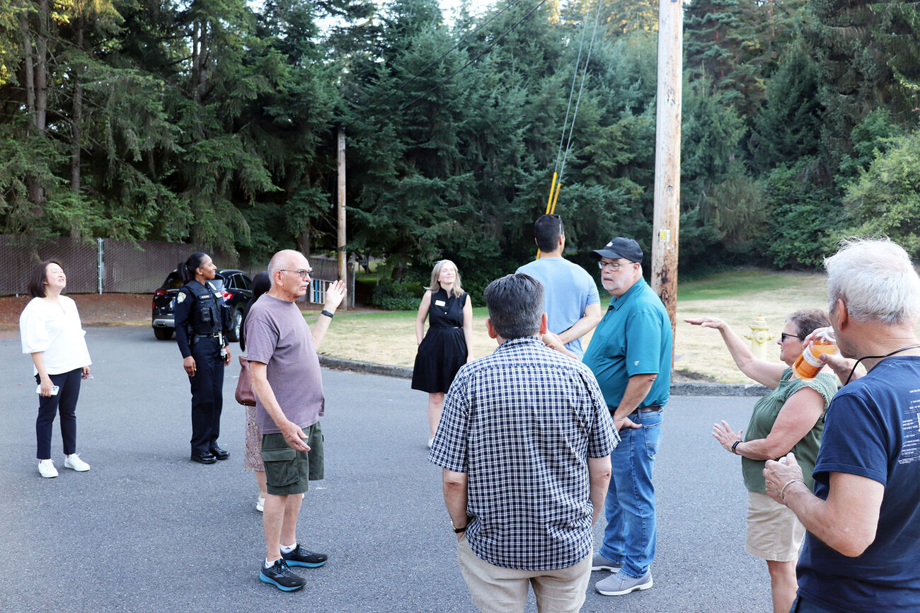 People talk on a street in Surrey Downs for Neighborhood Walks.