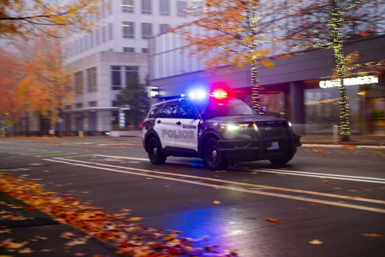 A Bellevue police SUV with lights flashing proceeds along 108th Avenue Northeast in downtown Bellevue.