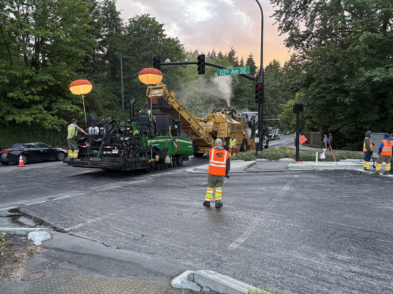 A paving machine runs past 112th Avenue Southeast.