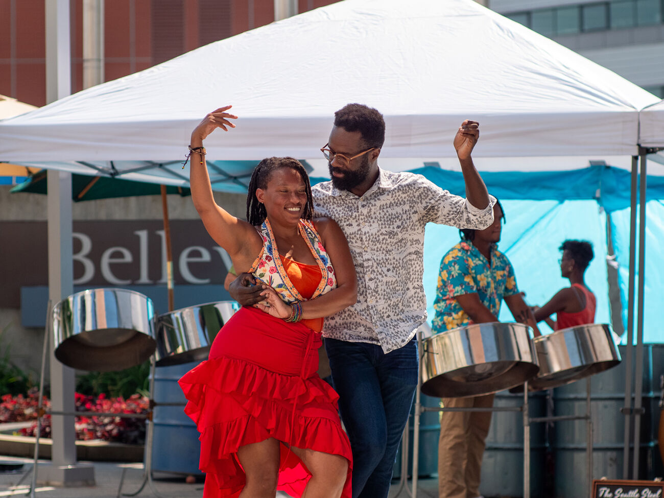 A couple dances, with a band behind them under a canopy, at Swing Arts Foundation's free jazz and swing dance lesson social at City Hall Plaza. 