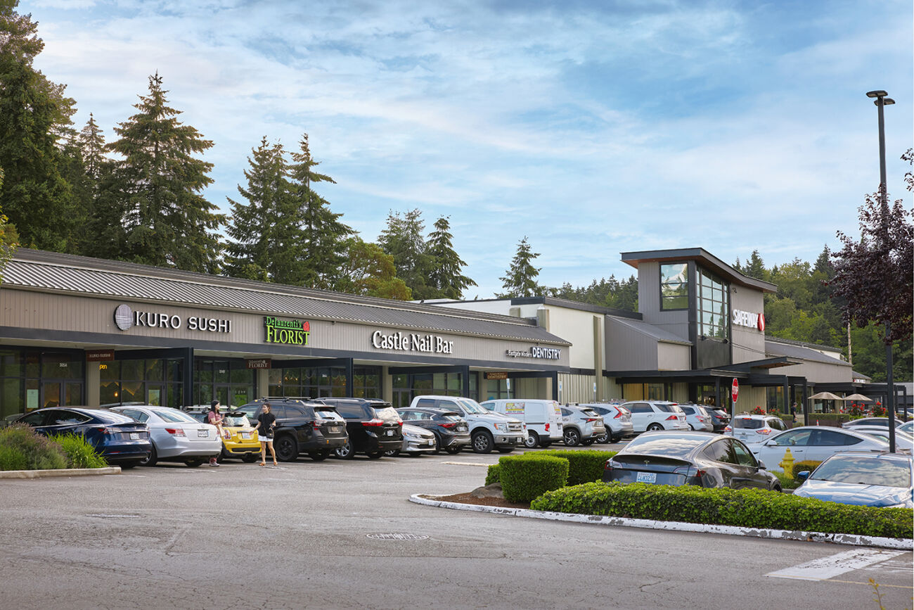 A row of restaurants and shops and the parking lot in front of them