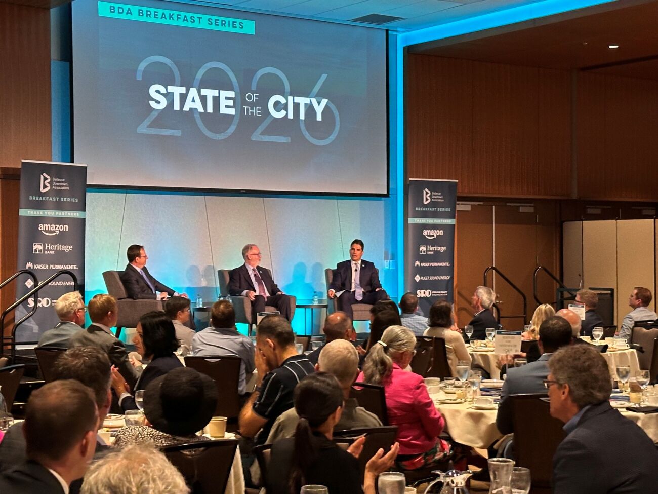 Mayor Mo Malakoutian (right) and Deputy Mayor Dave Hamilton (center) discuss Bellevue while seated on the stage at Meydenbauer Center.