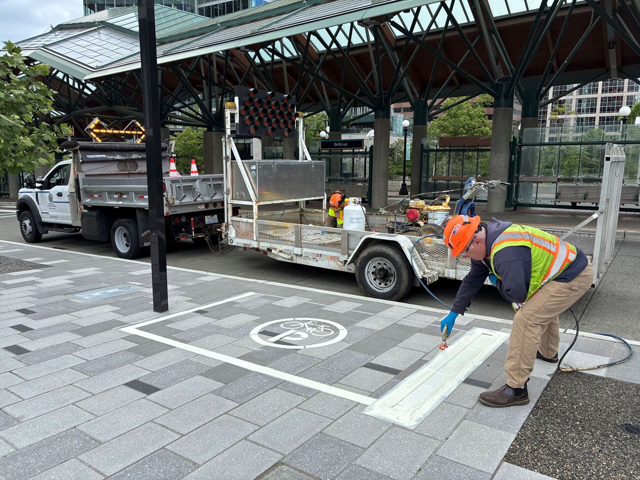 A contractor marks a large rectangle on a Bellevue sidewalk where Lime devices should be parked.