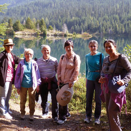 A group of people by a mountain lake