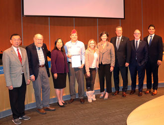 The council presents a proclamation about Veterans Day to an American Legion representative.